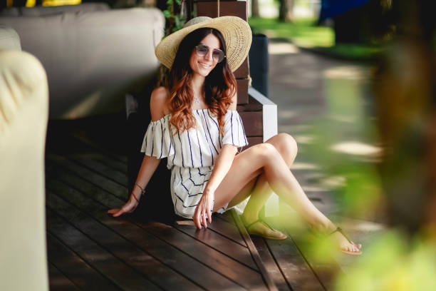 A girl in a summer dress, hat and sandals on the terrace. A girl in a summer dress, hat and sandals on the terrace sundress stock pictures, royalty-free photos & images