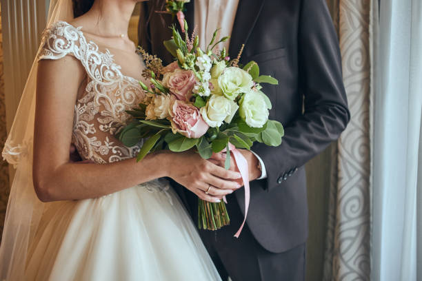 bride holding a wedding bouquet in the hands standing near groom - women bride personal accessory adult imagens e fotografias de stock