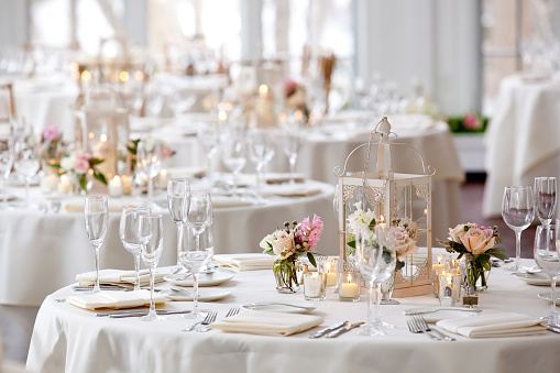 Elegant wedding banquet with golden vases, candlestick holders and little flower bouquets