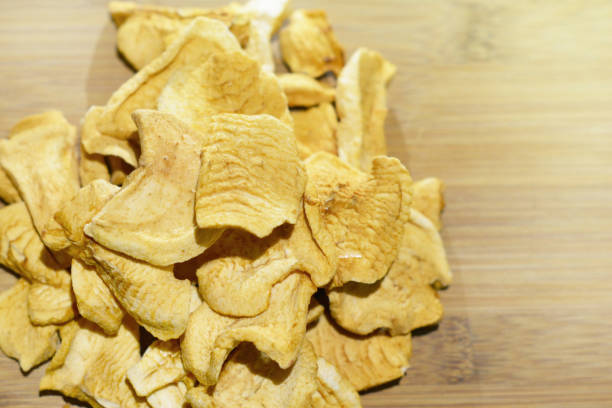 istock Sliced dried homemade apple chips on a wooden table 1127610432
