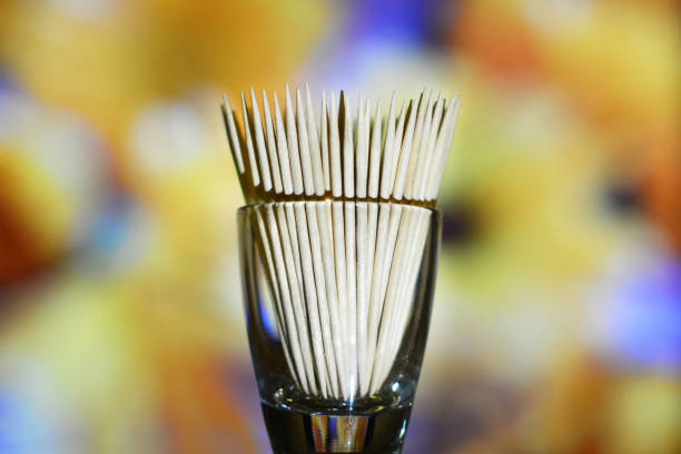 istock Wooden toothpicks in a glass container on a multicolor background 1127610503