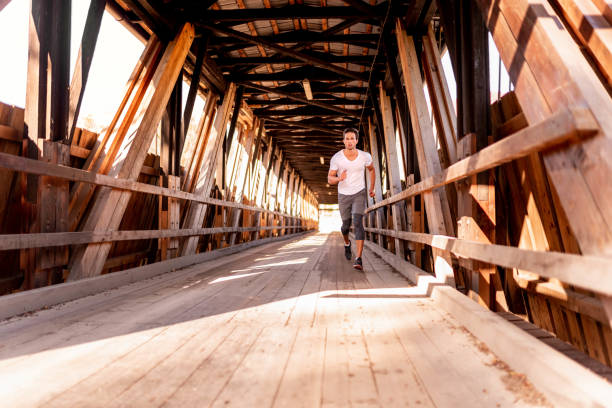 istock Athlete running on the old wooden bridge 1127610813