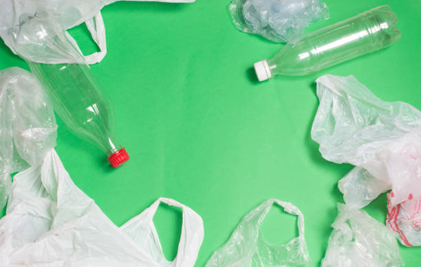 istock plastic bags and bottles on a green background with space for text.ecology mockup 1127611222