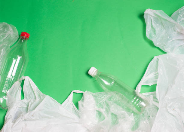 istock plastic bags and bottles on a green background with space for text.ecology mockup 1127611223