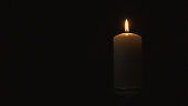 Burning a large candle in the dark