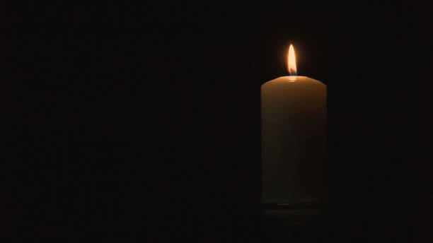 сжигание большой свечи в темноте - мемориал стоковые фото и изображения