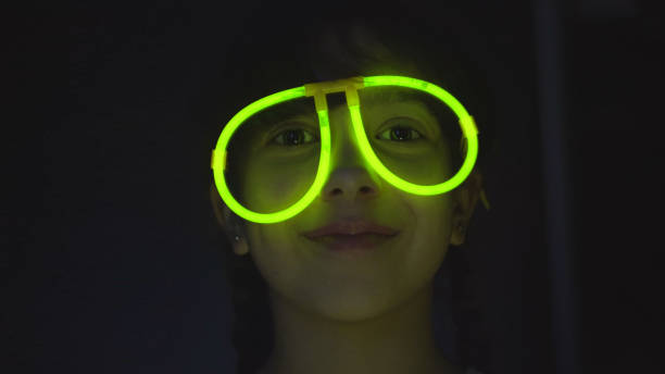 istock Girl in neon glasses on dark background 1127612311