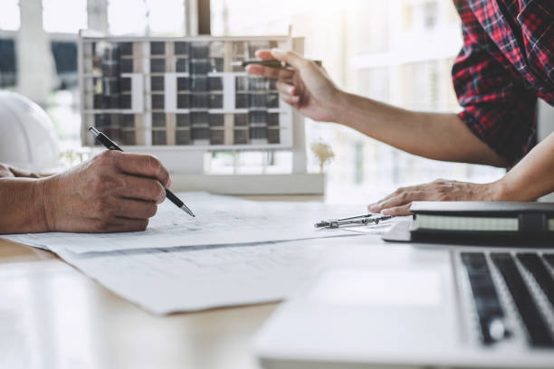 istock Construction and structure concept of Engineer or architect meeting for project working with partner and engineering tools on model building and blueprint in working site 1127612445