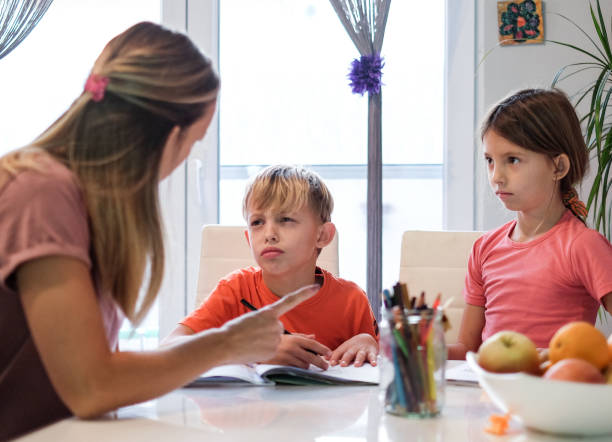 istock Mom helps children to do homework 1127620300