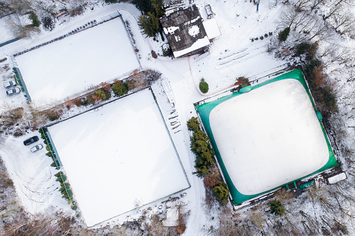 Snow-covered tennis courts and indoor tennis centre - winter, aerial view