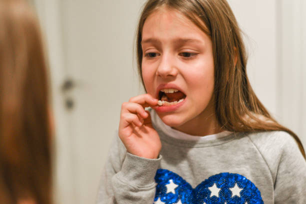 istock Little girl with her loose tooth 1127625491