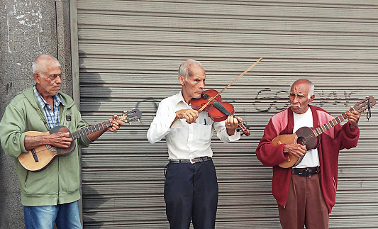 Caracas, Venezuela - February 24, 2018: Senior street musicians playing the Violin and Cuatro in Caracas Venezuela