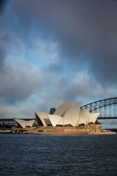 teatro dell'opera di sydney con nuvole drammatiche all'alba - sydney opera house sydney australia opera house bridge foto e immagini stock