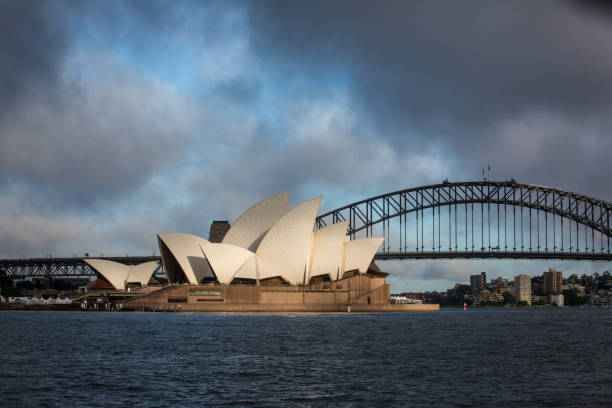 teatro dell'opera di sydney con nuvole drammatiche all'alba - sydney opera house sydney australia opera house bridge foto e immagini stock