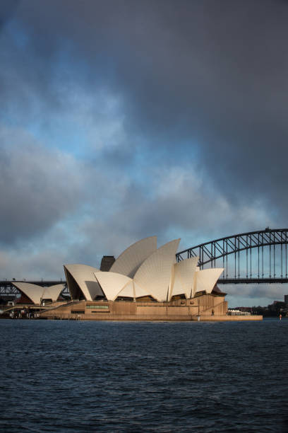 teatro dell'opera di sydney con nuvole drammatiche all'alba - sydney opera house sydney australia opera house bridge foto e immagini stock