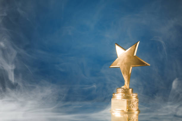 istock gold star trophy in smoke, blue background 1127633518