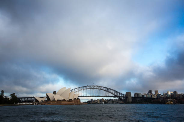 teatro dell'opera di sydney con nuvole drammatiche all'alba - sydney opera house sydney australia opera house bridge foto e immagini stock