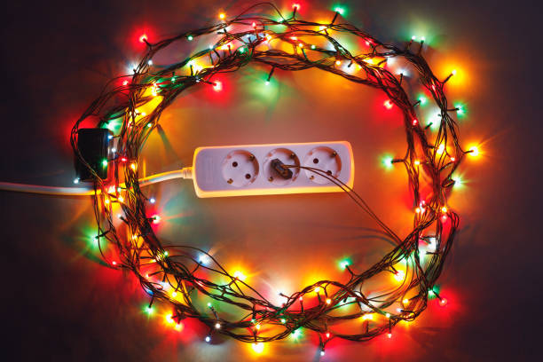istock Christmas garland lights circle around electric extension cord 1127634720