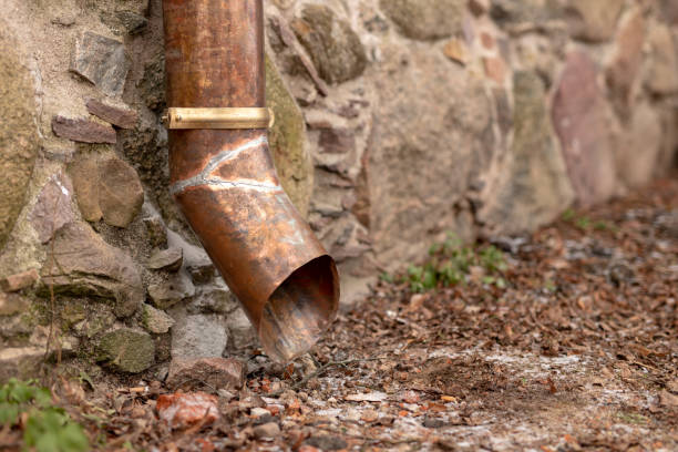 istock Old copper drain gutter in a brick building. Installation that drains water from the roof. Season winter. 1127635027