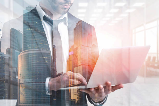 istock Man with laptop in office, cityscape 1127636165