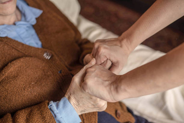 Helping hands. Caregiver helping elderly patient to get out of bed. nephropathy photos stock pictures, royalty-free photos & images