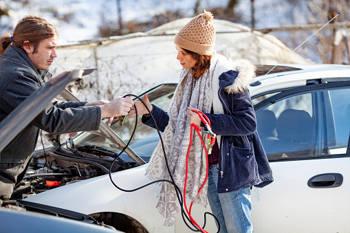 Adult Man Helping an Adult Woman To Jump Start Her Car.
