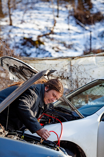 Adult Man Connecting Car Batteries With Jumper Cables.