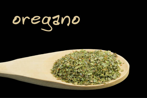 istock oregano on wooden spoon isolated on black background 1127639884