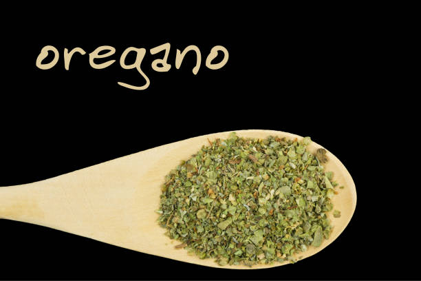 istock oregano on wooden spoon isolated on black background 1127640662