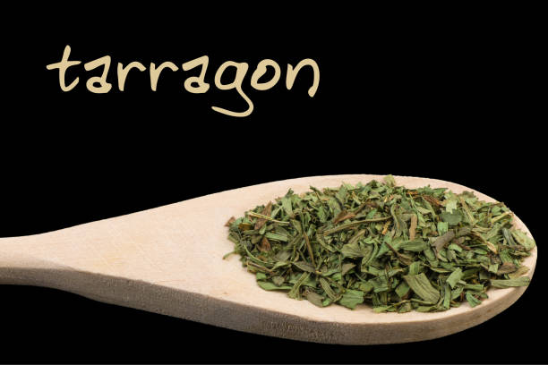 istock tarragon on wooden spoon isolated on black background 1127641152