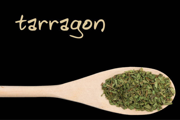 istock tarragon on wooden spoon isolated on black background 1127641251