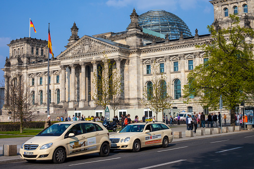 Berlin, Germany - April 18th 2011: Two Taxis waiting outside the historic Reichstag parliament building in Berlin, Germany.