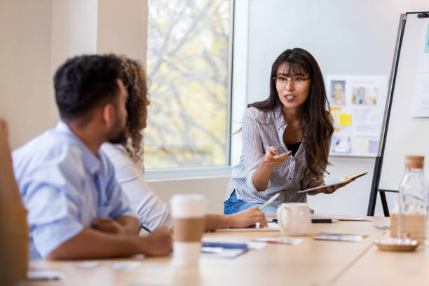 istock Female design manager explains new project to employees 1127642951