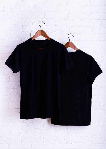 istock Black blank t-shirt, clothes hanging, white background. 1127642972