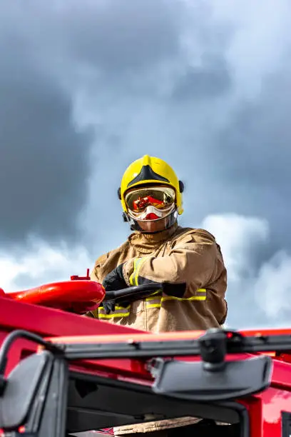 Firefighter taking part in training drill of a downed helicopter on a disused airfield.