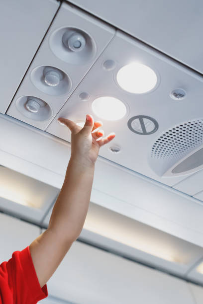 istock child hand pointing to the light lamp in airplane cabin 1127643503