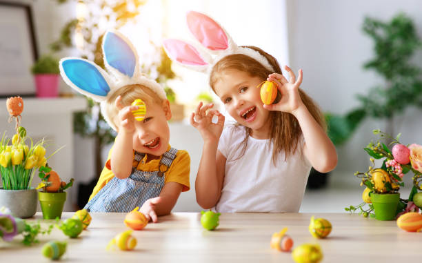 wesołych świąt! śmieszne śmieszne dzieci z uszami zając przygotowuje się do wakacji - easter baby rabbit eggs zdjęcia i obrazy z banku zdjęć