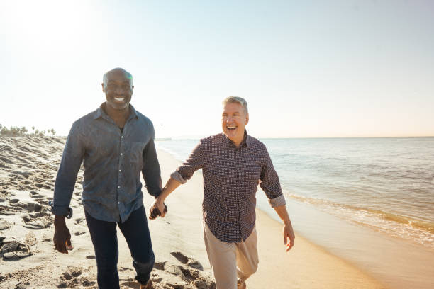 How to Retire Happy Senior couple  on the beach gay couple photos stock pictures, royalty-free photos & images