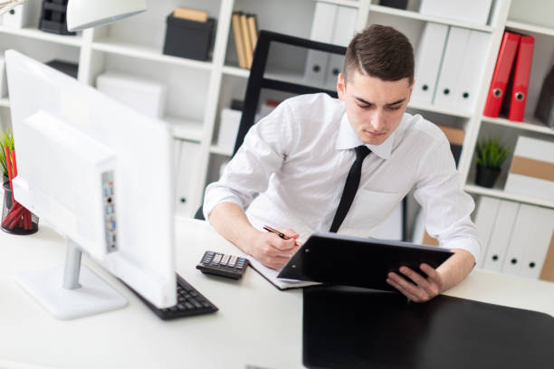 istock A young man sitting at a computer Desk in the office and working with documents. 1127651460