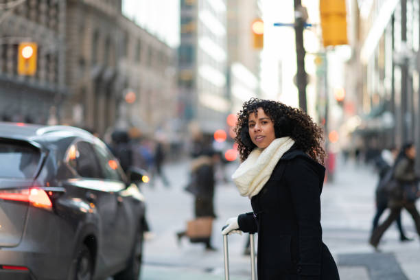 歩道上の女性が彼女に乗るのために待機します。 - taxi city life toronto ontario ストックフォトと画像