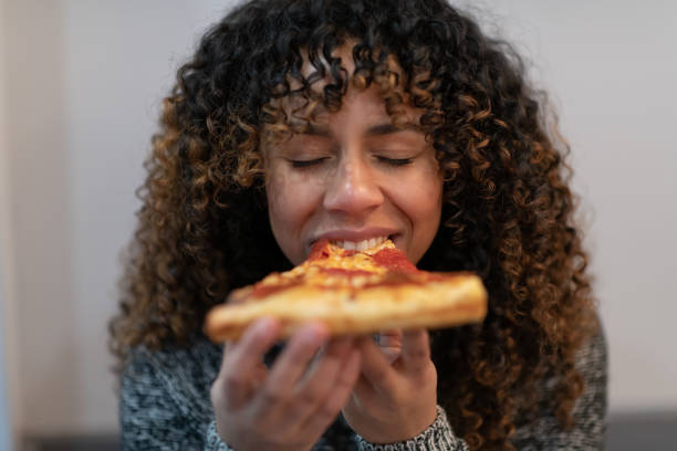 istock Woman eating pizza 1127652263