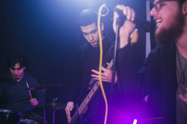 istock Male singer with microphone and rock and roll band 1127653893