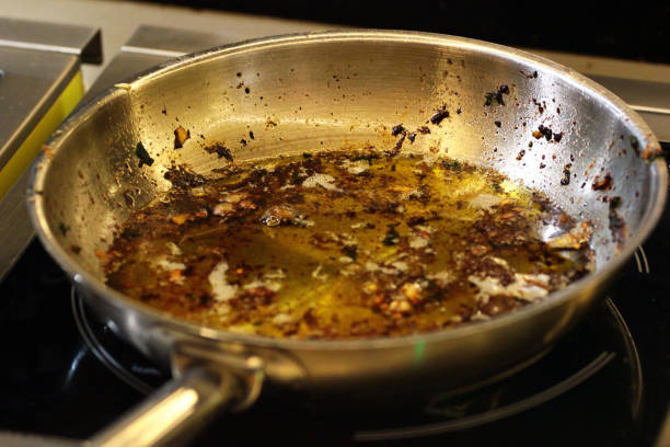 Frying pan with used oil on a stove after cooking stock photo