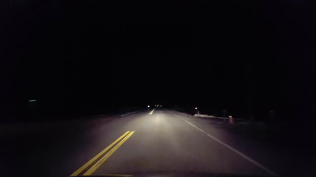 Driving Rural Countryside Road Into the City at Night.  Driver Point of View POV Entering Urban Lights From Country Street