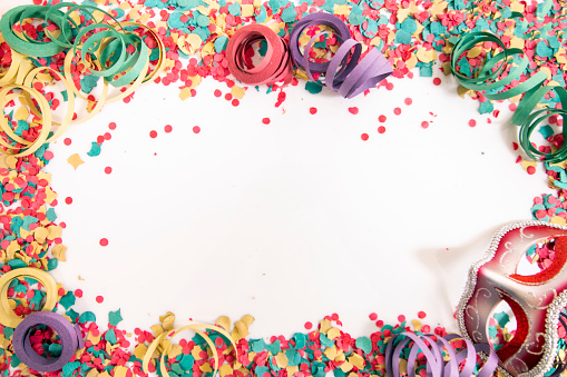 Mixed colorful confetti scattered on a white background.