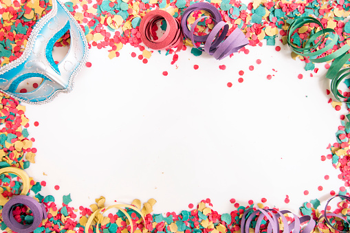 Mixed colorful confetti scattered on a white background.