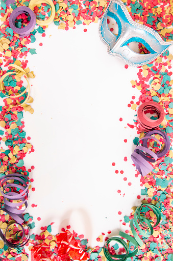 Mixed colorful confetti scattered on a white background.