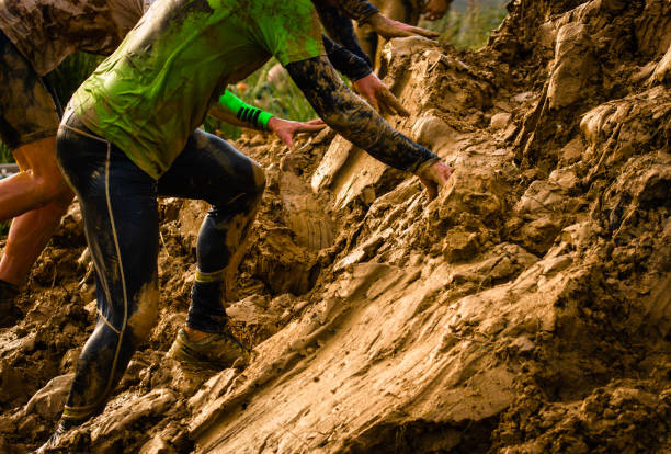 Muddy obstacle race runner in action. Mud run stock photo