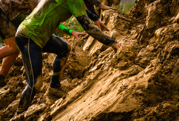 muddy obstacle race runner in action. mud run - mud run imagens e fotografias de stock