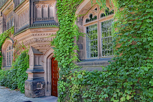 Princeton, NJ, USA - June 27, 2012:  Princeton University's spacious campus has elegant stone-clad buildings such as Pyne Hall, with intricate carving in its pink sandstone.